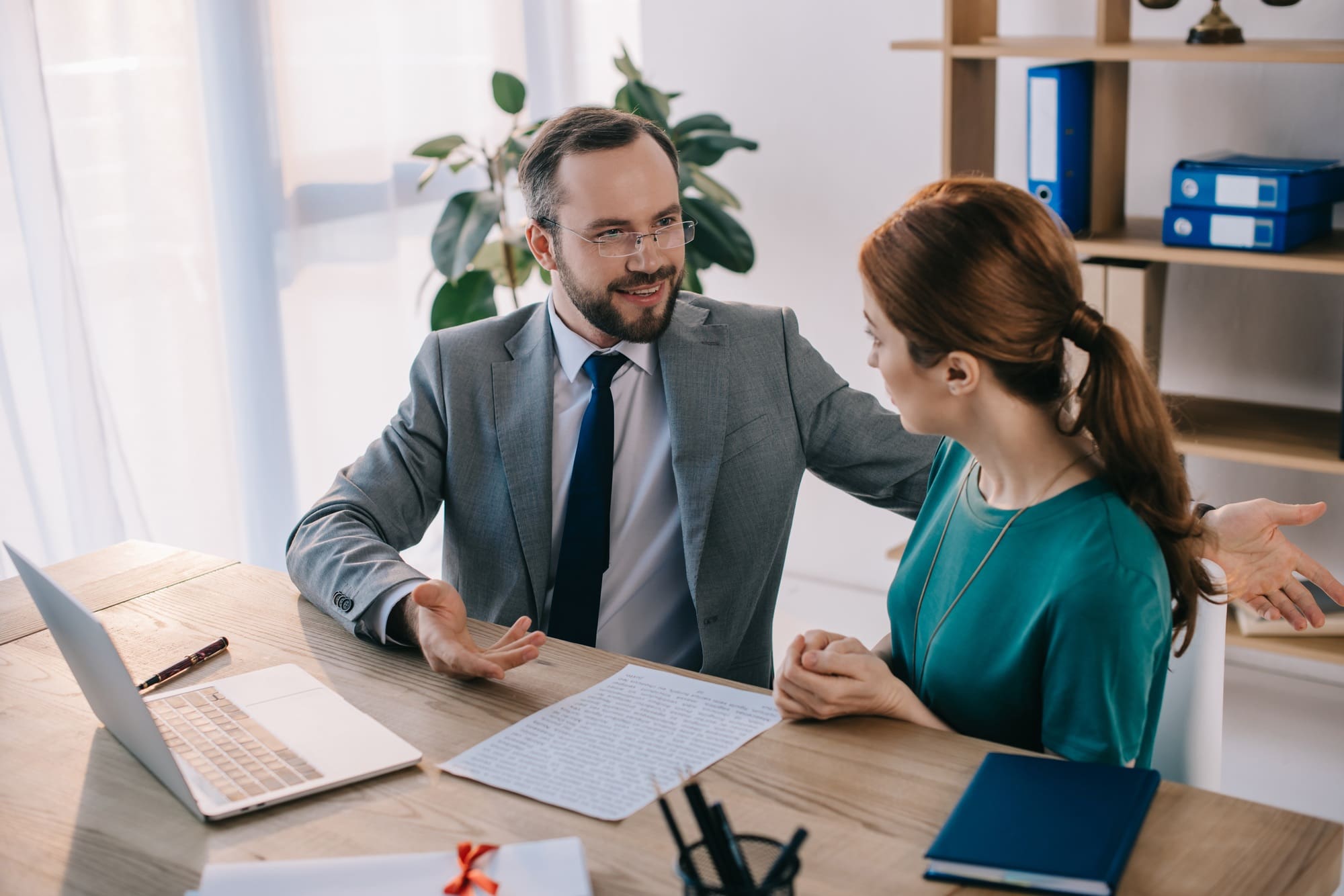businessman and client discussing contract during meeting in office