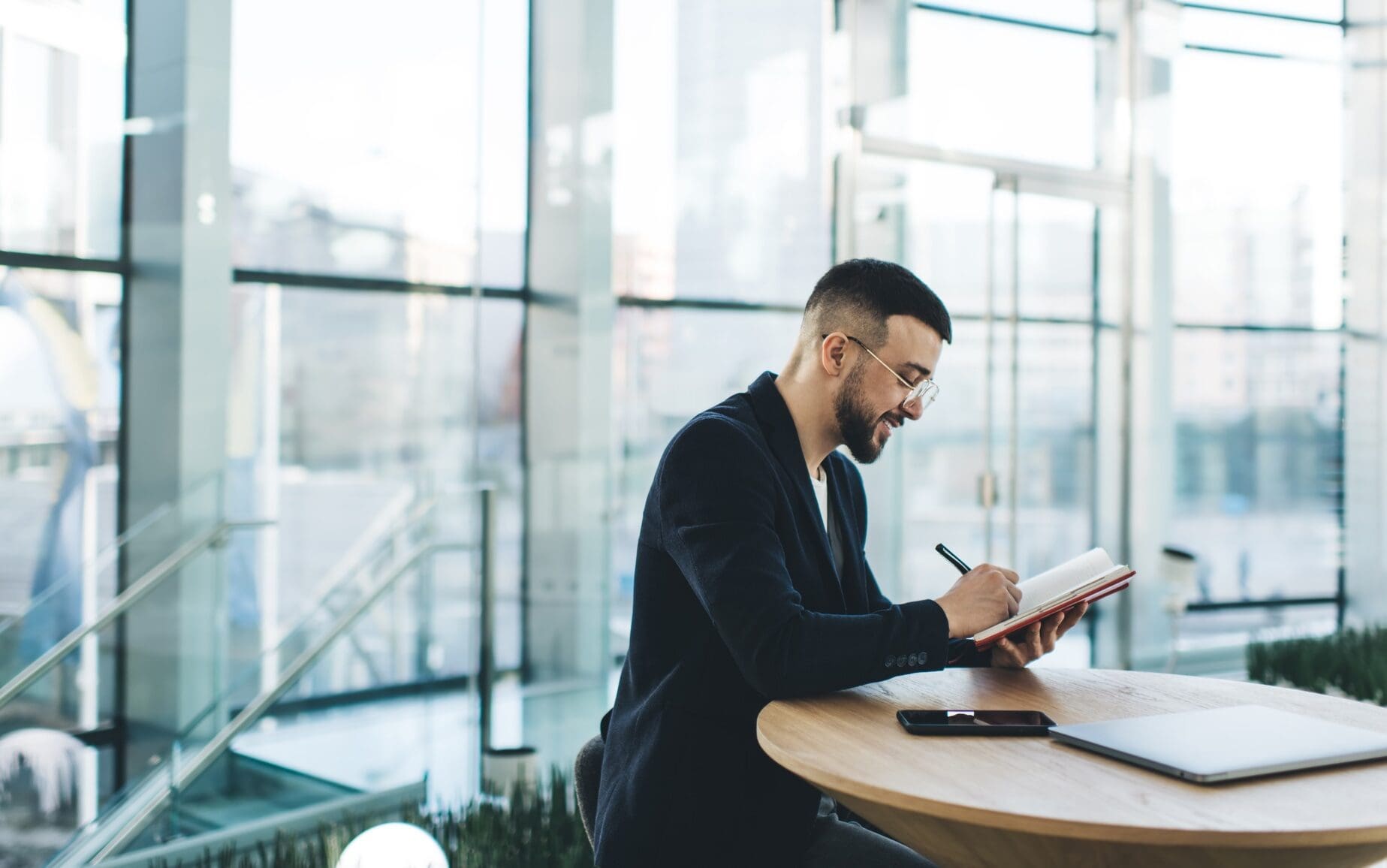Smiling man writing thoughts in planner